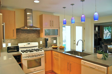 Inspiration for a contemporary u-shaped medium tone wood floor eat-in kitchen remodel in Raleigh with a drop-in sink, flat-panel cabinets, medium tone wood cabinets, gray backsplash, stone tile backsplash and stainless steel appliances