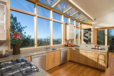 Trendy u-shaped medium tone wood floor eat-in kitchen photo in Other with an undermount sink, flat-panel cabinets, light wood cabinets, granite countertops, stone slab backsplash and stainless steel appliances