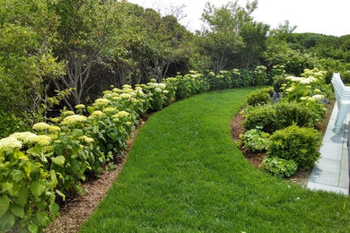 Photo of a mid-sized traditional full sun backyard stone landscaping in Boston.