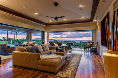Tropical open concept living room in Hawaii with a built-in media wall.