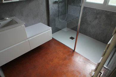 Immagine di una stanza da bagno minimal con pareti grigie, pavimento in cemento e top in cemento