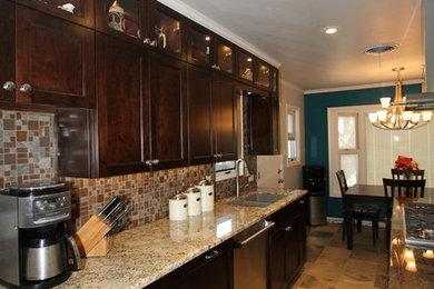 Mid-sized elegant galley slate floor and beige floor eat-in kitchen photo in Other with a double-bowl sink, dark wood cabinets, granite countertops, brown backsplash, ceramic backsplash, stainless steel appliances, an island and shaker cabinets
