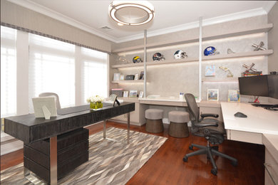 Cette image montre un bureau minimaliste avec un mur gris, un sol en bois brun, aucune cheminée, un bureau indépendant et un sol marron.