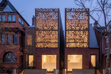 Inspiration for a mid-sized contemporary red three-story brick exterior home remodel in Toronto