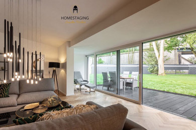 Großes, Offenes Modernes Wohnzimmer in grau-weiß mit weißer Wandfarbe, braunem Holzboden und braunem Boden in Köln