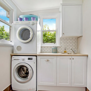 Small Laundry with Laminate bench and subway tiles