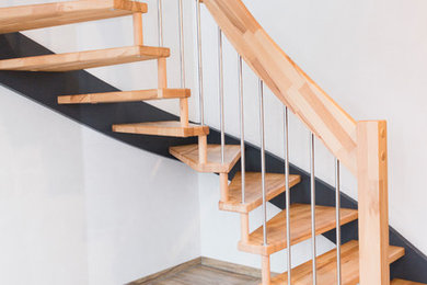 Mittelgroße, Gewendelte Moderne Treppe mit gebeizten Holz-Treppenstufen, Mix-Geländer und offenen Setzstufen in Sonstige