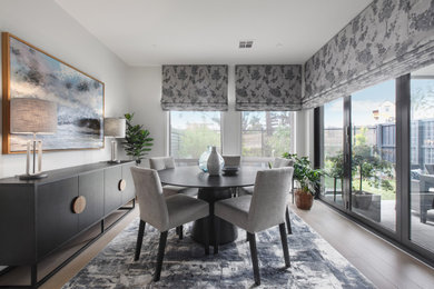 Photo of a contemporary dining room in Melbourne with grey walls, dark hardwood floors and brown floor.