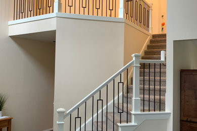 Imagen de escalera en L clásica de tamaño medio con escalones enmoquetados, contrahuellas enmoquetadas y barandilla de varios materiales