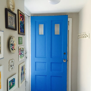 This is an example of a small eclectic vestibule in New York with white walls, a single front door and a blue front door.
