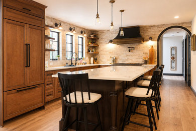 Transitional kitchen photo in Seattle with recessed-panel cabinets, brown cabinets, paneled appliances and an island