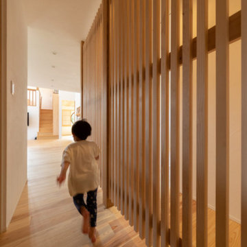 壁ではなく木製格子でつなげる廊下。帰宅後必ずリビングを通り各個室へ向かう動線つくり