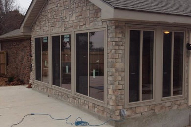 Example of a mid-sized transitional beige one-story stone exterior home design in Other with a shingle roof