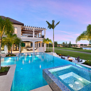 Geräumiger Klassischer Infinity-Pool hinter dem Haus in individueller Form mit Wasserspiel und Natursteinplatten in Miami