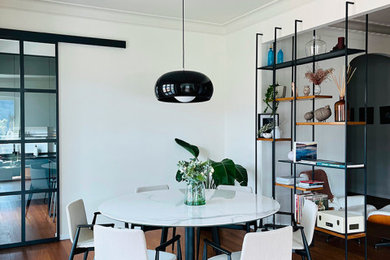 Foto di una sala da pranzo aperta verso il soggiorno moderna di medie dimensioni con pareti bianche e pavimento in laminato