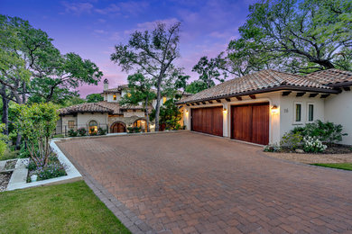 Example of a huge tuscan multicolored two-story mixed siding house exterior design in Austin with a hip roof and a tile roof