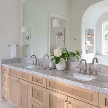 Reeded oak vanity detail with stone counters and polished nickel f