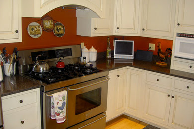 Kitchen - mid-sized l-shaped light wood floor kitchen idea in New York with an undermount sink, raised-panel cabinets, beige cabinets, granite countertops and stainless steel appliances