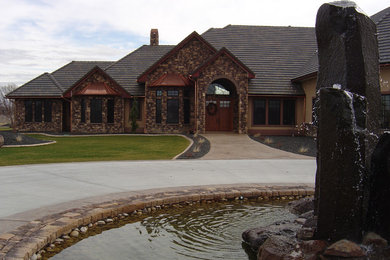 Inspiration for a mid-sized traditional two-storey brown house exterior in Boise with stone veneer, a hip roof and a shingle roof.