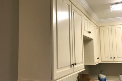 Example of a large classic l-shaped eat-in kitchen design in New Orleans with a drop-in sink, raised-panel cabinets, beige cabinets, granite countertops, stainless steel appliances, an island and beige countertops