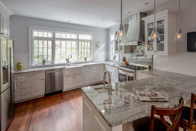 Inspiration for a large traditional eat-in kitchen in Boston with a farmhouse sink, raised-panel cabinets, white cabinets, granite benchtops, white splashback, subway tile splashback, stainless steel appliances and dark hardwood floors.