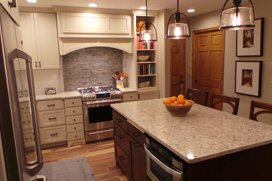 Example of a transitional l-shaped eat-in kitchen design in Minneapolis with an undermount sink, recessed-panel cabinets, gray cabinets, quartz countertops, gray backsplash, stone tile backsplash and stainless steel appliances