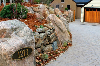 Photo of an eclectic driveway for fall in Denver with a retaining wall and concrete pavers.