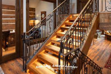 На фото: прямая лестница в классическом стиле с деревянными ступенями и металлическими перилами
