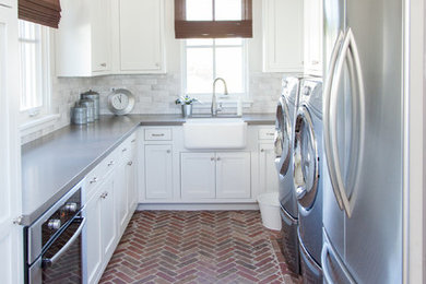 Large transitional u-shaped brick floor utility room photo in Phoenix with a farmhouse sink, white cabinets, beige walls, a side-by-side washer/dryer and shaker cabinets