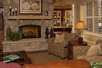 Inspiration for a mid-sized rustic open concept medium tone wood floor and brown floor family room remodel in Raleigh with a standard fireplace, a stone fireplace and no tv