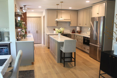 Example of an eat-in kitchen design in Other with quartz countertops, stainless steel appliances, an island and white countertops