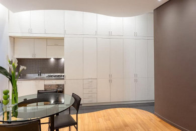 Idee per una piccola sala da pranzo aperta verso il soggiorno minimal con pareti bianche, pavimento in pietra calcarea e pavimento grigio