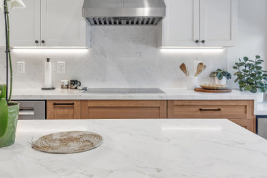 Inspiration for a l-shaped kitchen remodel in San Francisco with an undermount sink, shaker cabinets, light wood cabinets, white backsplash, stainless steel appliances and white countertops
