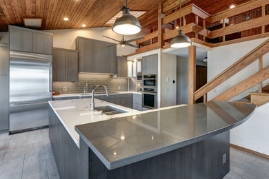 Eat-in kitchen - large contemporary porcelain tile and gray floor eat-in kitchen idea in Seattle with an undermount sink, flat-panel cabinets, gray cabinets, quartz countertops, gray backsplash, glass tile backsplash, stainless steel appliances, an island and white countertops