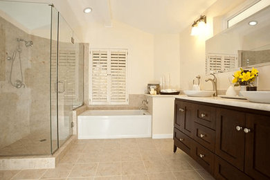 Example of a mid-sized classic master beige tile and ceramic tile ceramic tile and beige floor bathroom design in San Francisco with shaker cabinets, dark wood cabinets, a two-piece toilet, beige walls, a vessel sink, marble countertops and a hinged shower door