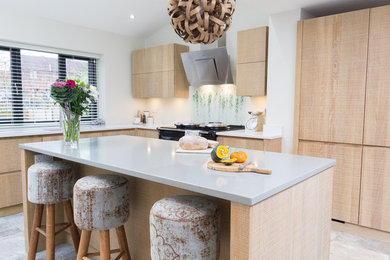 Medium sized scandinavian l-shaped kitchen in Other with flat-panel cabinets, light wood cabinets, composite countertops, glass sheet splashback, black appliances, ceramic flooring, an island, grey floors, grey worktops, a submerged sink and multi-coloured splashback.