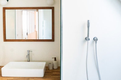 Réalisation d'une salle de bain principale minimaliste de taille moyenne avec une baignoire encastrée, WC suspendus, un mur jaune, un lavabo posé et meuble simple vasque.