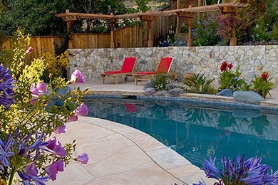 Inspiration for a large mediterranean backyard custom-shaped pool in San Francisco with natural stone pavers.