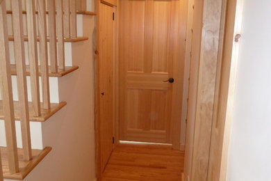 Hallway - mid-sized modern medium tone wood floor hallway idea in Boston with white walls