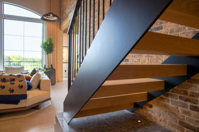 Staircase - mid-sized industrial wooden straight metal railing and brick wall staircase idea in Salt Lake City