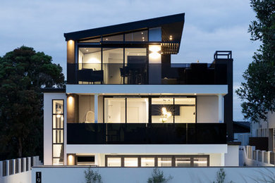 This is an example of a contemporary three-storey white house exterior in Hamilton with a shed roof.