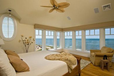 Photo of a large beach style master bedroom in Boston with beige walls, medium hardwood floors and no fireplace.