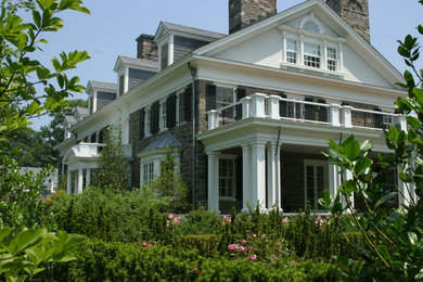 This is an example of a large traditional two-storey beige exterior in New York with stone veneer.