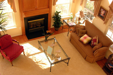 Example of a light wood floor living room design in Phoenix with a standard fireplace, a wood fireplace surround and beige walls