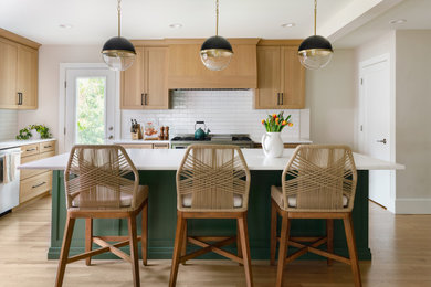 Mid-sized minimalist l-shaped open concept kitchen photo in St Louis with recessed-panel cabinets, green cabinets, quartz countertops, white backsplash, ceramic backsplash, stainless steel appliances, an island and white countertops