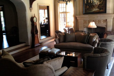 Living room - large traditional open concept dark wood floor living room idea in Dallas with beige walls, a stone fireplace and a concealed tv