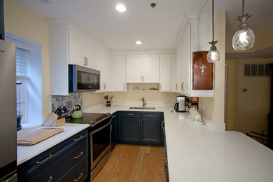 Inspiration for a small transitional u-shaped light wood floor and brown floor kitchen remodel in Philadelphia with a single-bowl sink, shaker cabinets, blue cabinets, marble countertops, stainless steel appliances, a peninsula and white countertops