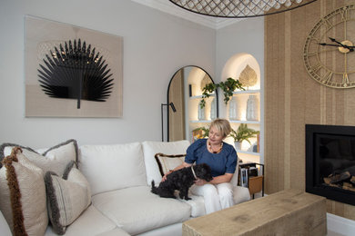 Living room - mid-sized contemporary beige floor living room idea in Other with white walls, a standard fireplace, a plaster fireplace and a tv stand