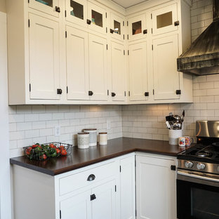 Réalisation d'une petite arrière-cuisine champêtre en U avec un évier posé, un placard à porte shaker, des portes de placard blanches, une crédence blanche, une crédence en carrelage métro, un électroménager en acier inoxydable, un sol en bois foncé, un îlot central, un sol marron et un plan de travail en zinc.