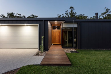 This is an example of a mid-sized contemporary front door in Sunshine Coast with a single front door and a medium wood front door.